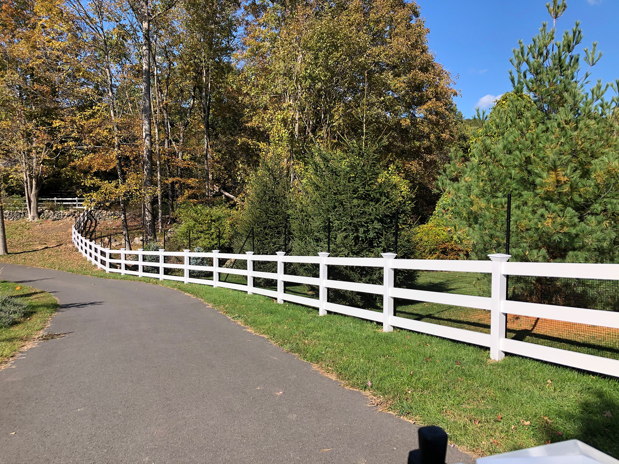 beautiful white picket fence in a wooded area.
