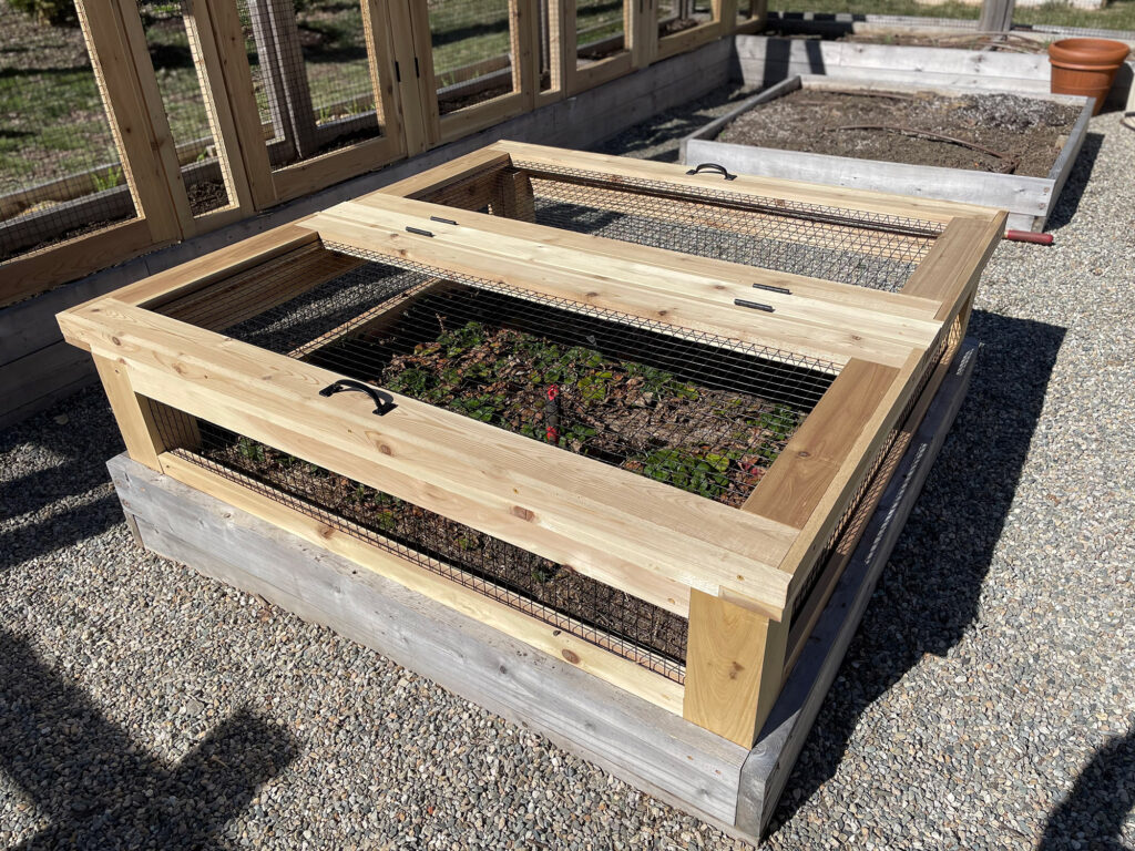 A wooden box filled with plants, perfect for garden fencing.
