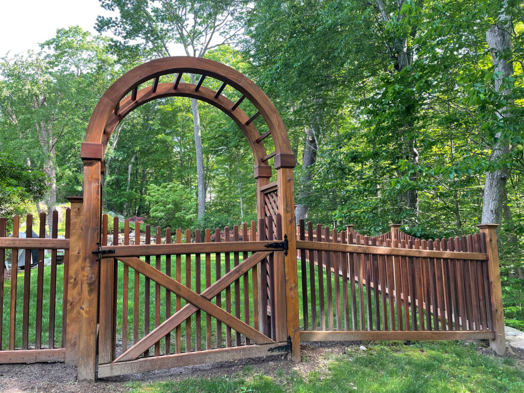 A wooden gate in a wooded area.